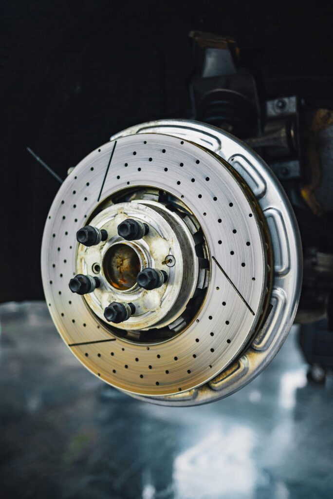 Detailed view of a car brake disc, highlighting its metallic structure and components in a workshop setting.