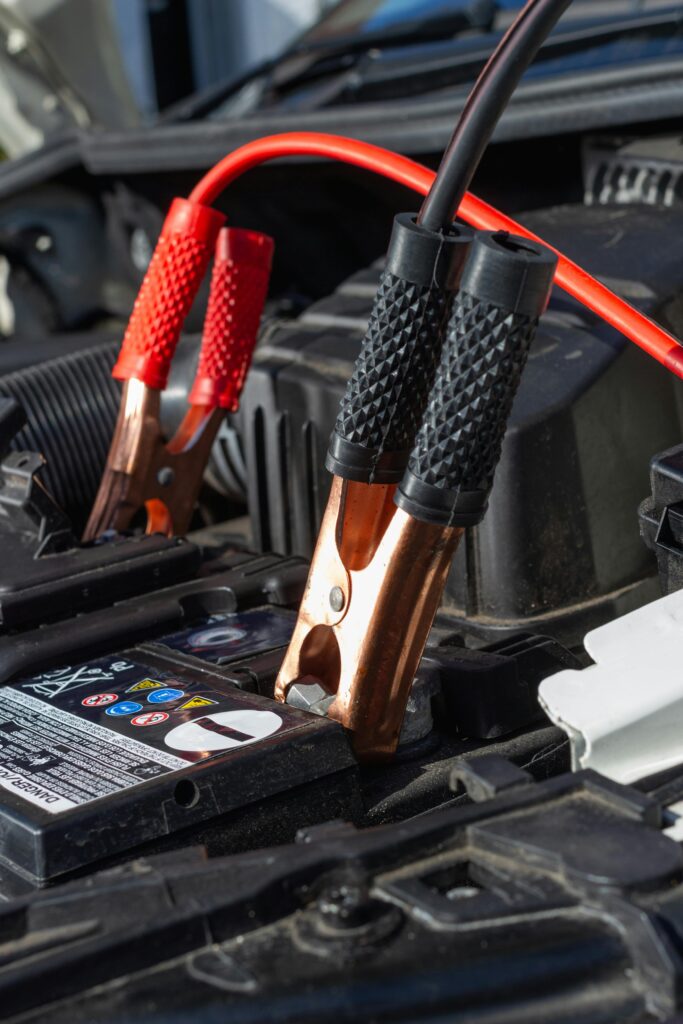 Close-up view of jumper cables charging a car battery.